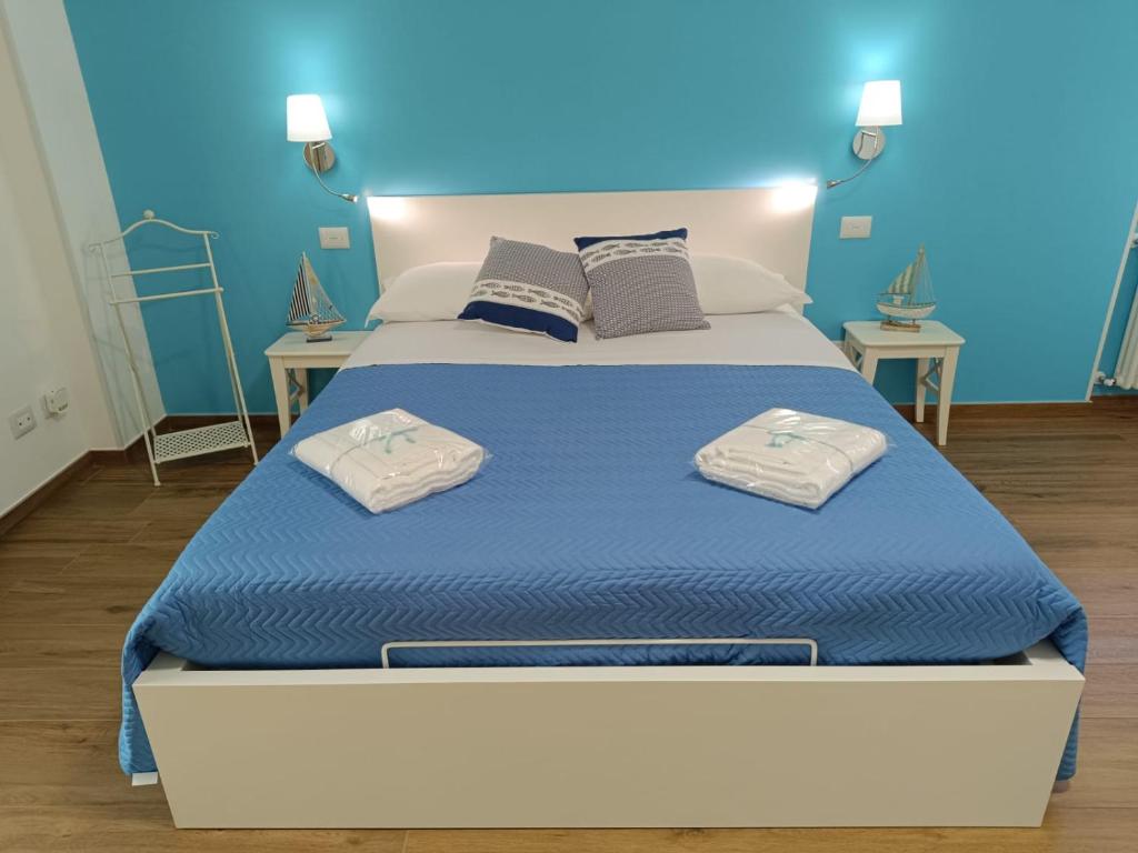 a bedroom with a large bed with two towels on it at Zagare & Trabocchi - Dimora di mare in Rocca San Giovanni