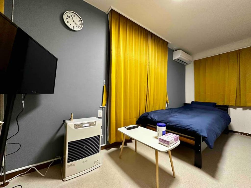 a bedroom with a bed and a tv and a table at Coop Sunlight - Vacation STAY 19687 in Sapporo