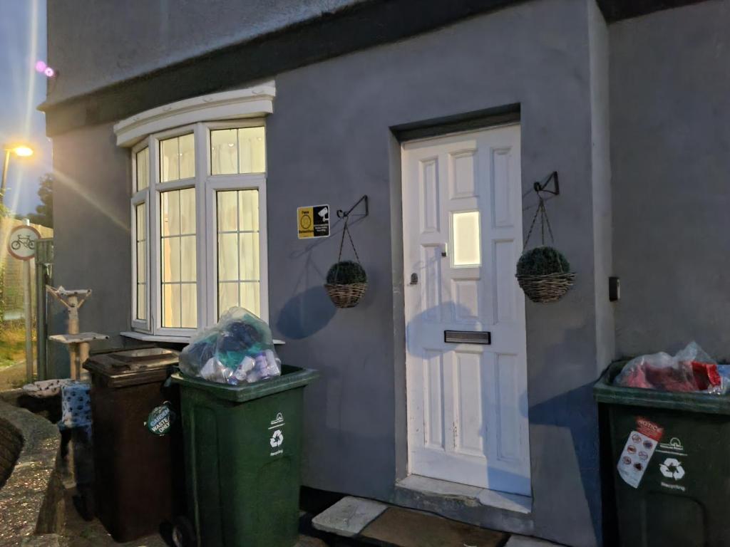 a house with two trash cans next to a door at New double room on gf in London