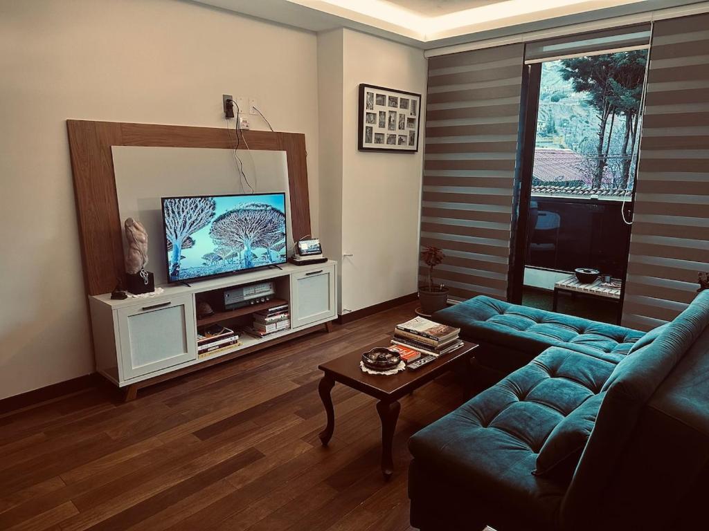 un soggiorno con un divano blu e una televisione di Luxury one bedroom apartment, high amenities a La Paz
