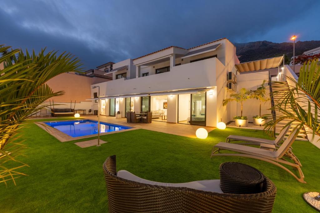 a villa with a yard with a swimming pool at Saras Village in Adeje