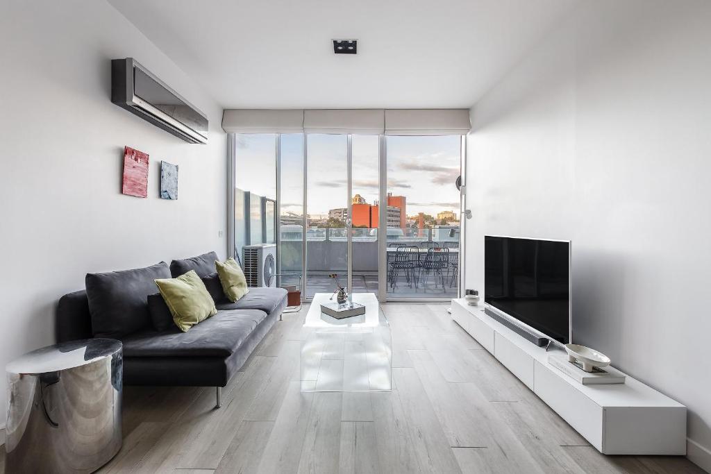 a living room with a couch and a tv at 'Swanston Central' Wellness-infused City Living in Melbourne