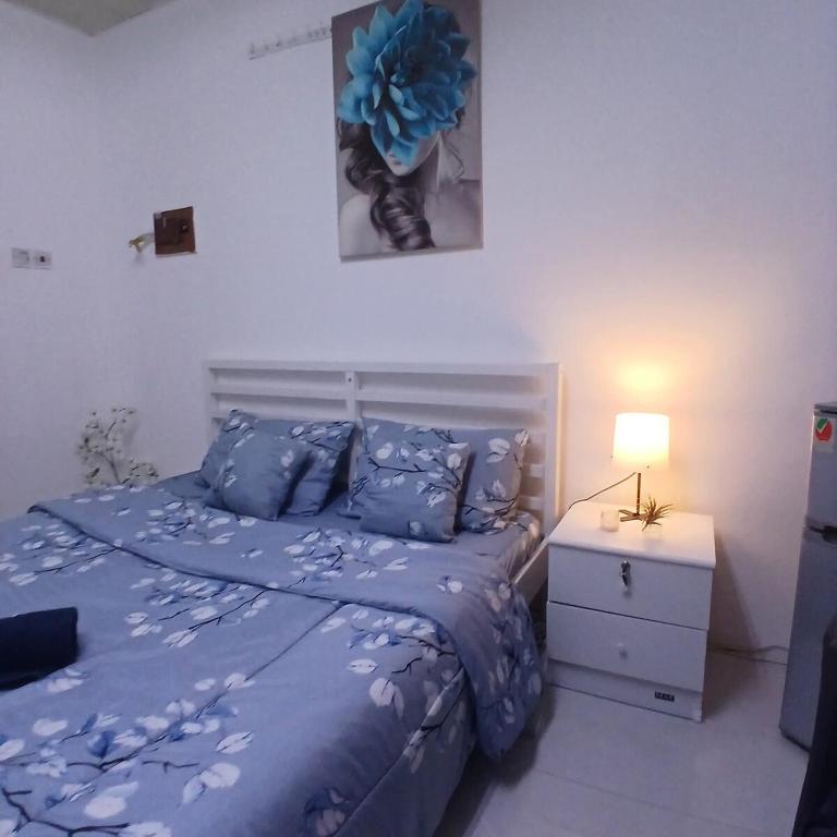 a bedroom with a blue bed and a night stand at Al Ain Blue in Al Ain