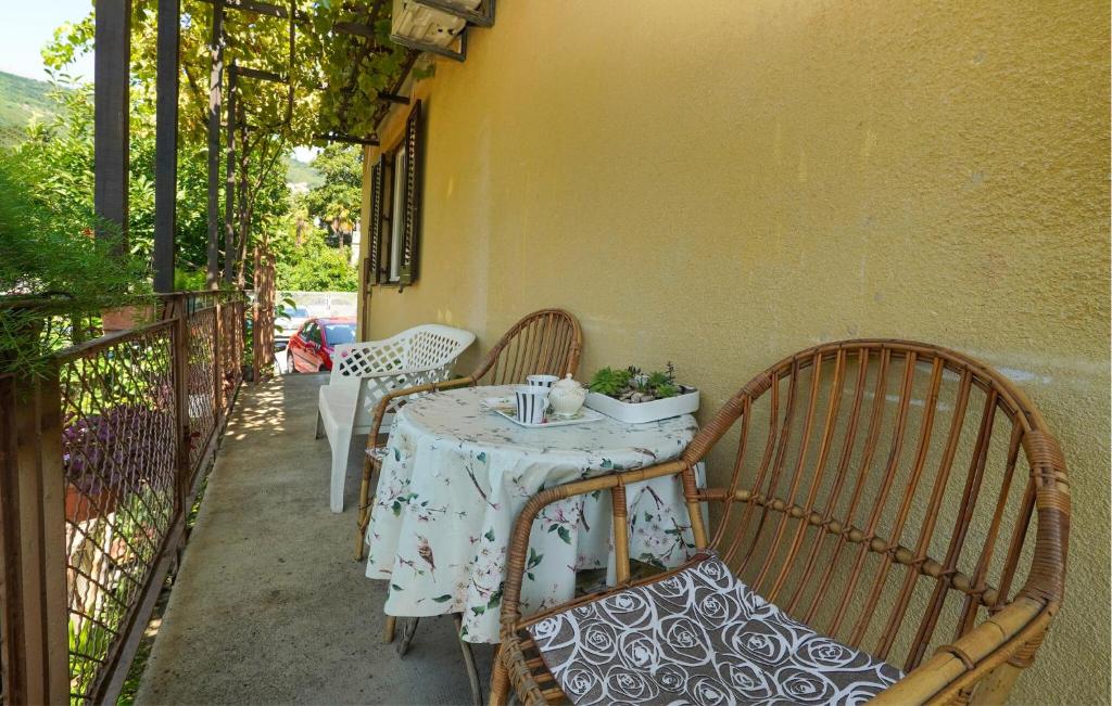 a table and chairs on a balcony with a table and a table at Nice Apartment In Lovran With Wifi in Lovran