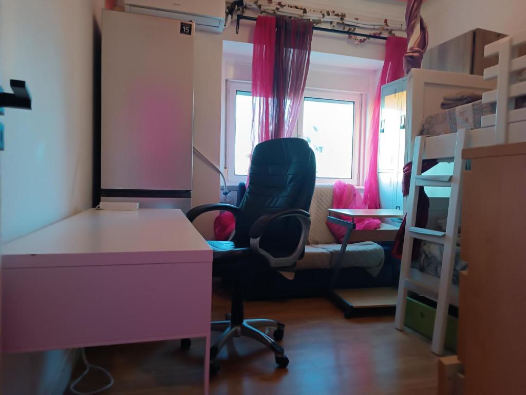 a room with a desk and a chair and a bed at Sams Rooms - Solo Female Guest House in Amadora