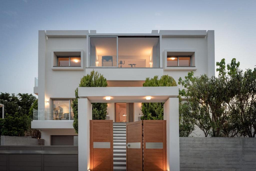 a large white house with a wooden door at Extravagant Crete Villa 4 Bedrooms Villa Yasemí I Private Pool And Outdoor Amenities Bbq Rethymno in Prínos