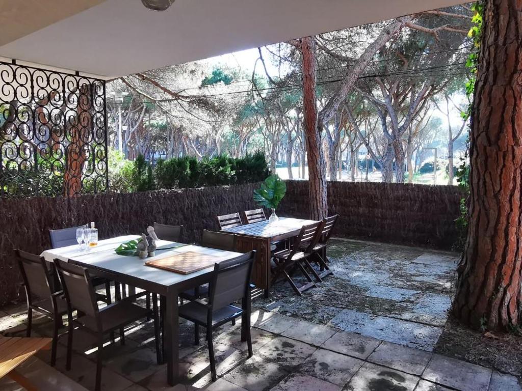 un patio con 2 tavoli, sedie e un albero di Fantástica villa en Playa de Aro, a 100m del mar, con terraza y 6 habitaciones - ES-209-11 a Platja  d'Aro