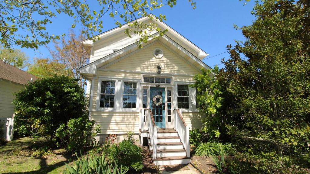 una casa bianca con scale che conducono alla porta d'ingresso di The Duck Pond Cottage a Cape May