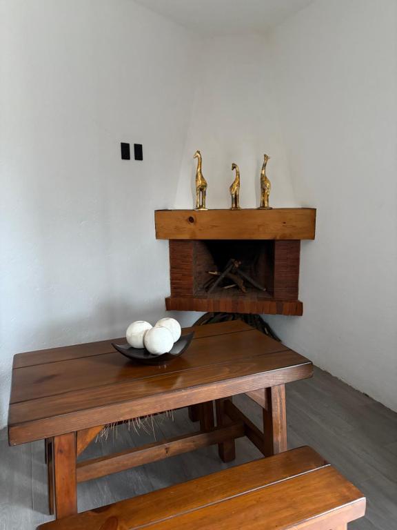 a table with a fireplace with two brass animals on it at Casa Guaria Morada in Valle de Bravo
