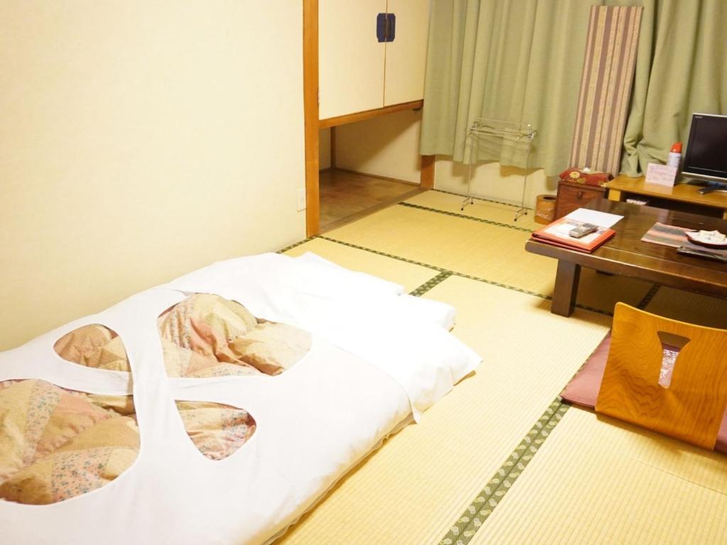 une chambre avec un lit et un bureau et un bureau dans l'établissement Yamaichi, à Shizukuishi