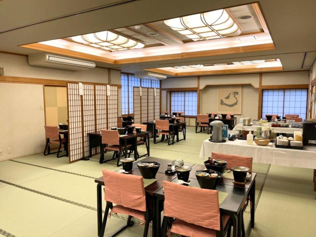 une salle à manger avec tables, chaises et fenêtres dans l'établissement Yamaichi, à Shizukuishi