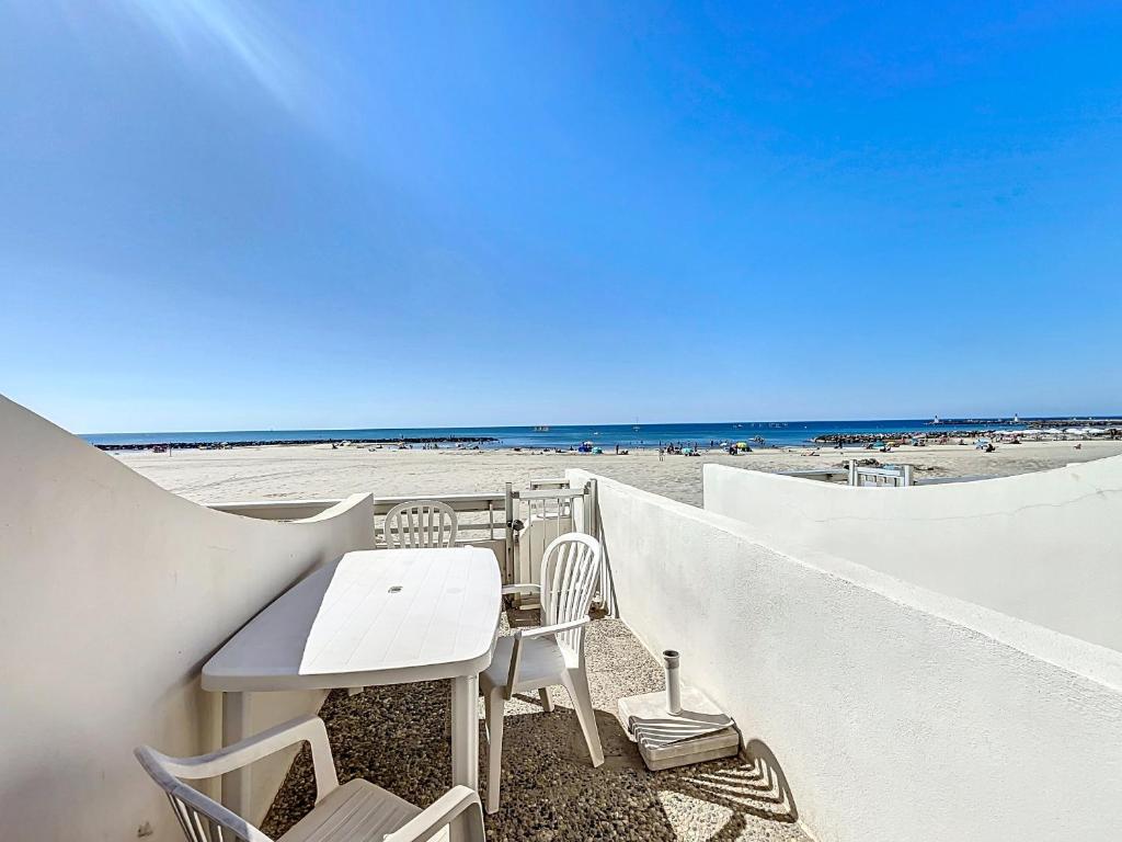 - une table et des chaises assises sur la plage dans l'établissement Studio pour 4 avec terrasse et accès direct plage - Carnon, proche Montpellier - Wifi inclus - FR-1-715-51, à Mauguio