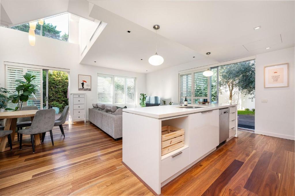 メルボルンにあるBeachfront Hamptonのキッチンとテーブルとソファのあるリビングルーム