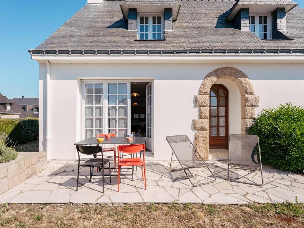 a patio with a table and chairs in front of a house at Maison Néo-Bretonne 6 pièces avec jardin à Carnac - 9 personnes - FR-1-477-264 in Carnac