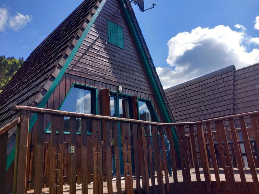 ein Haus mit einem Walmdach und einer Holzterrasse in der Unterkunft Chalet individuel chaleureux au pied des pistes - FR-1-787-128 in Laveissière