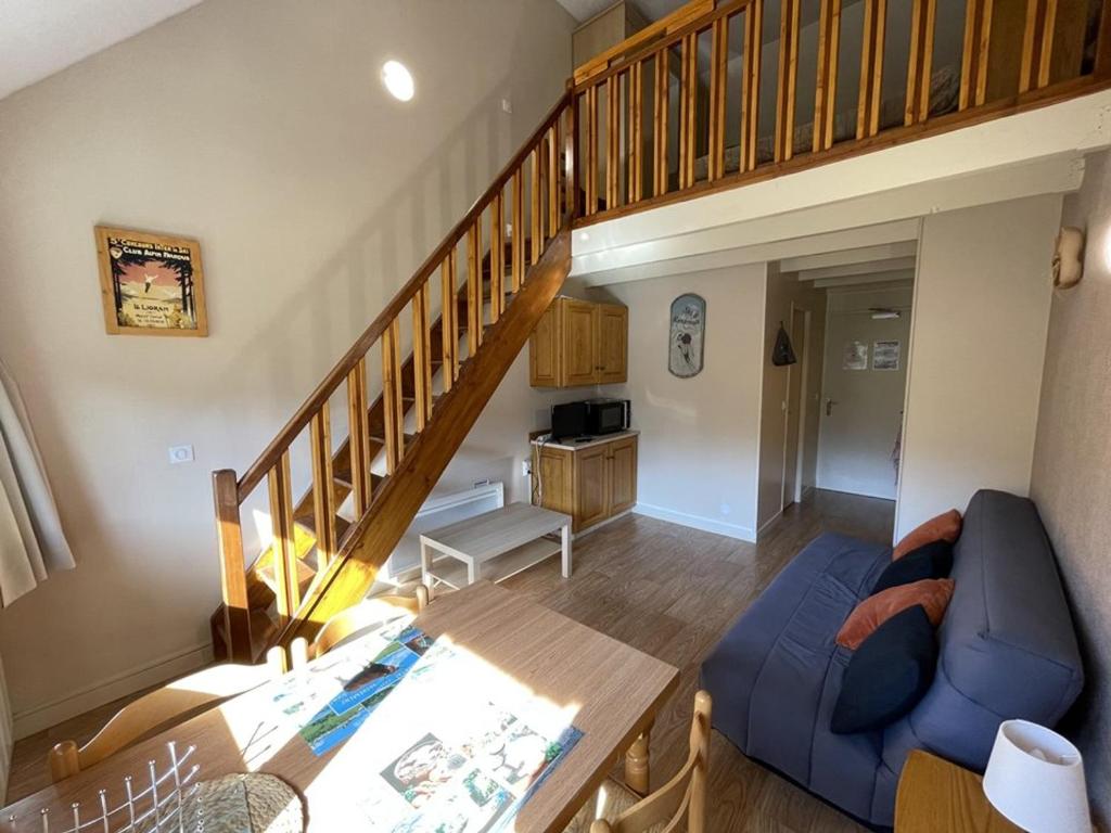 un soggiorno con un divano blu e una scala di Charmant Duplex pour 5 pers., Wi-Fi & Parking au Lioran - FR-1-787-108 a Laveissière