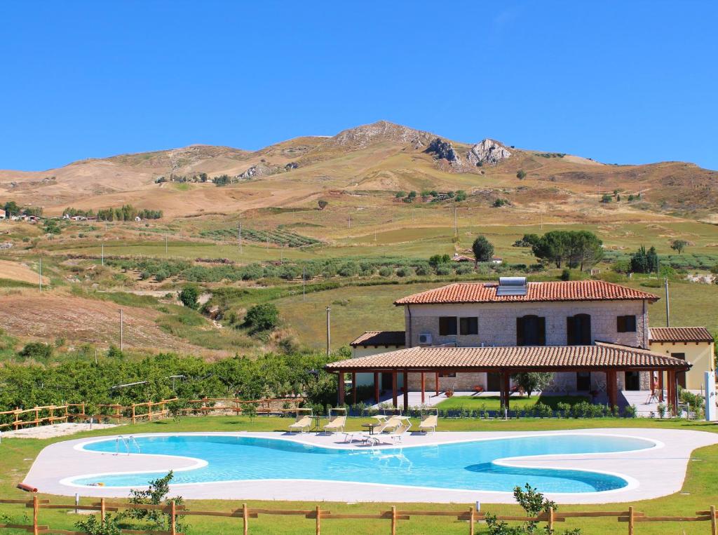 ein Haus mit einem Pool vor einem Berg in der Unterkunft Tenuta Lanza Il Mulino in Acquaviva Platani