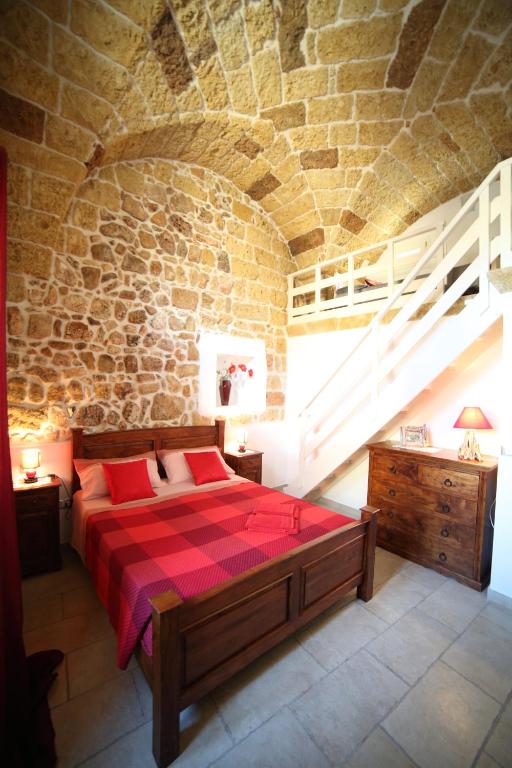 a bedroom with a bed in a stone wall at La Corte Delle Sterne in Morciano di Leuca