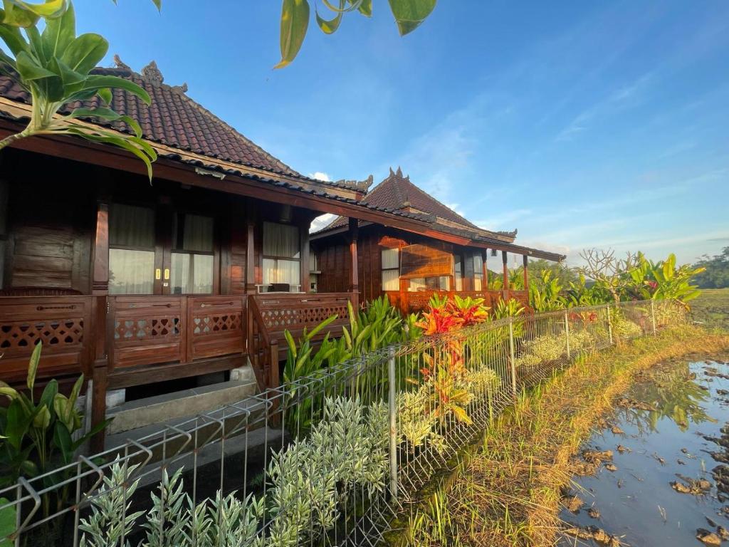 a house with a fence in front of it at Precious Journey Retreat in Ubud
