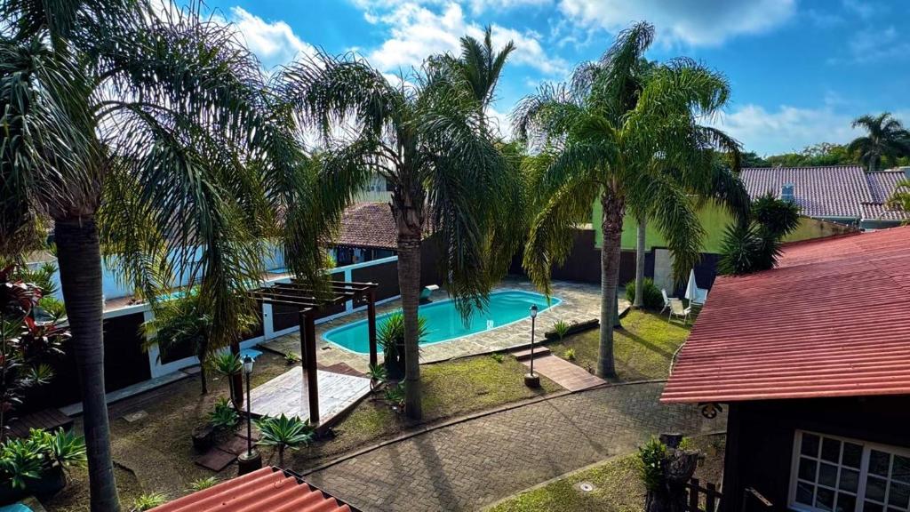 an aerial view of a house with a swimming pool and palm trees at Pousada Laranjal em Pelotas in Pelotas
