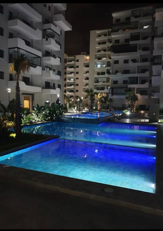 a swimming pool in front of a building at night at Ocean Park Apartment for rent in Casablanca