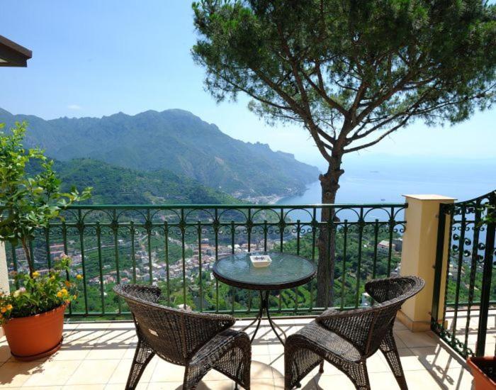 una mesa y sillas en un balcón con vistas en Auditorium Rooms, en Ravello