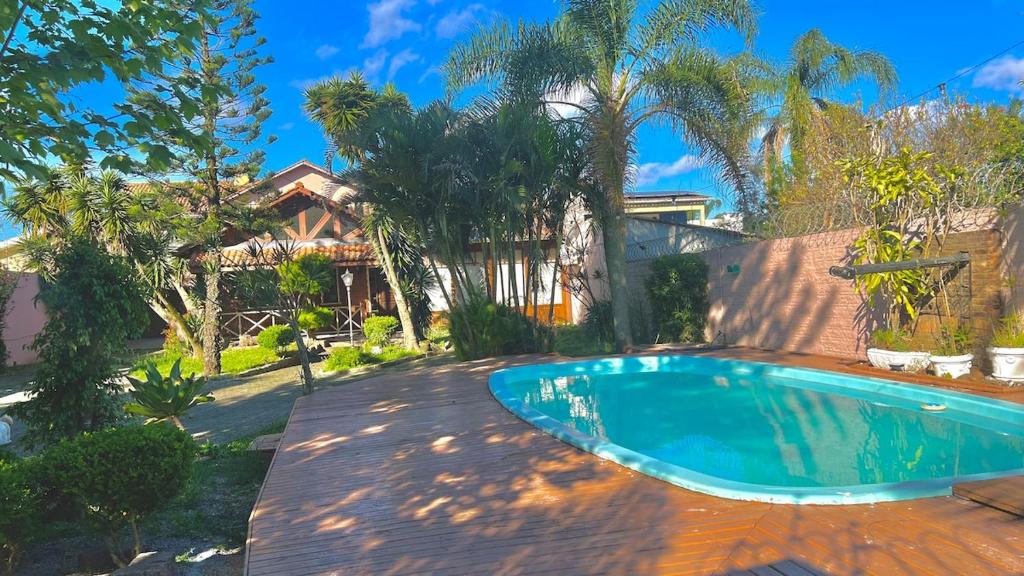 a swimming pool in a yard with a house at Ampla e luxuosa casa com áreas de lazer in Pelotas