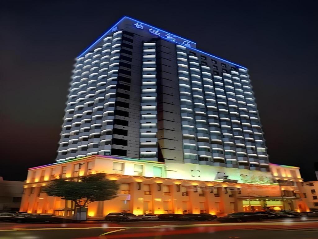 Un gran edificio con un cartel azul encima. en Greatwall Hotel - Zhengzhou, en Zhengzhou