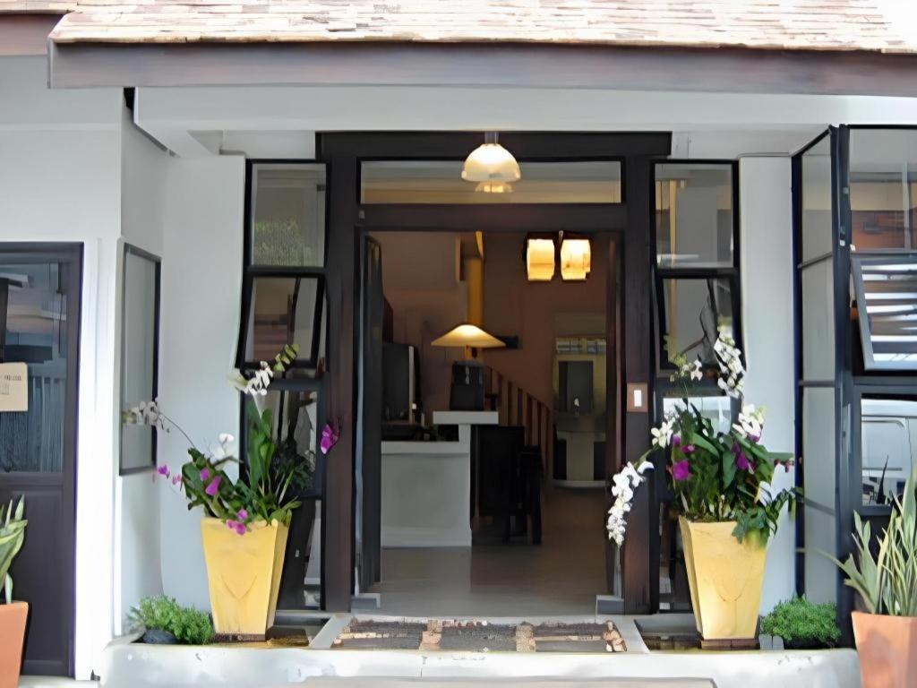 une porte d'entrée d'une maison avec des plantes en pot dans l'établissement Montrara Happy House Hotel, à Chiang Mai