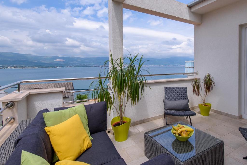 d'un balcon avec un canapé et une vue sur l'eau. dans l'établissement Apartments Salona, à Trogir