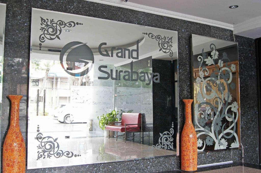 a store window with two orange vases and a red chair at Grand Hotel Surabaya in Surabaya