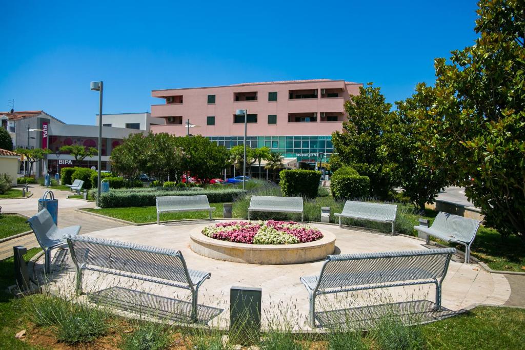 un gruppo di panchine in un parco con fontana di Studio Stylish a Vodice