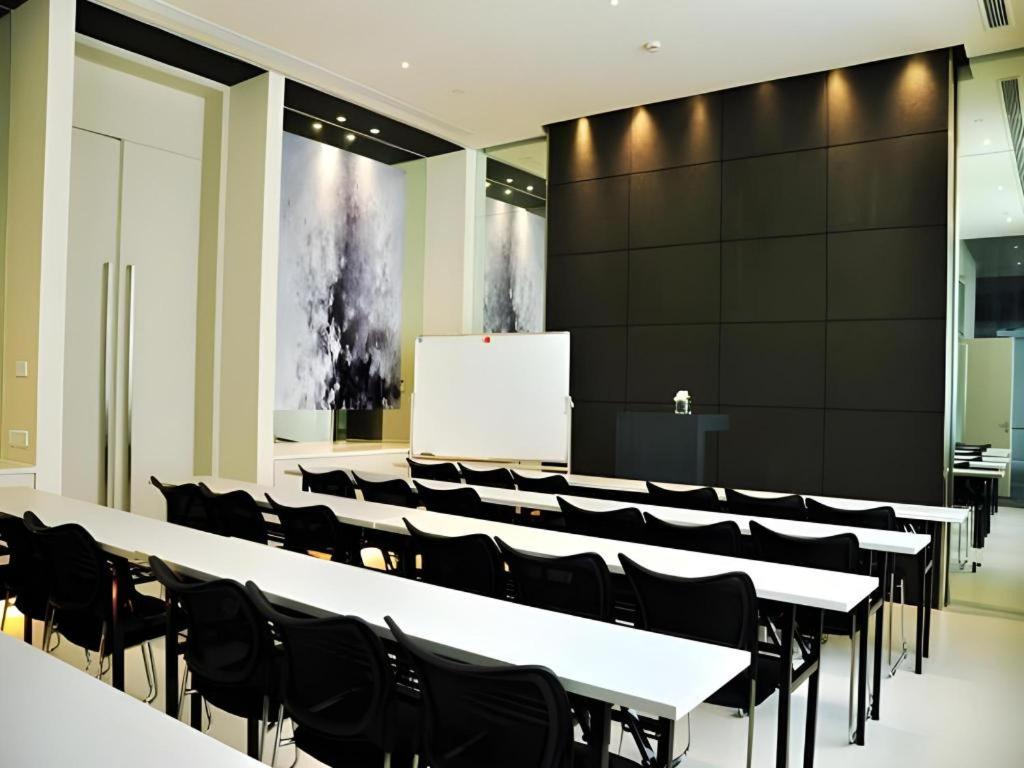 a lecture hall with white tables and black chairs at Jinjiang Inn Select Xuzhou Suning Plaza Jinguang East Road in Xuzhou