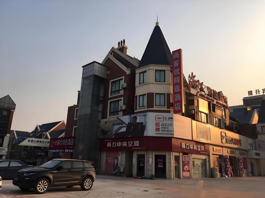 une voiture noire garée devant un immeuble dans l'établissement Thank Inn Hotel Jiangsu Huaian Lianshui Baiyue Square, à Paifang