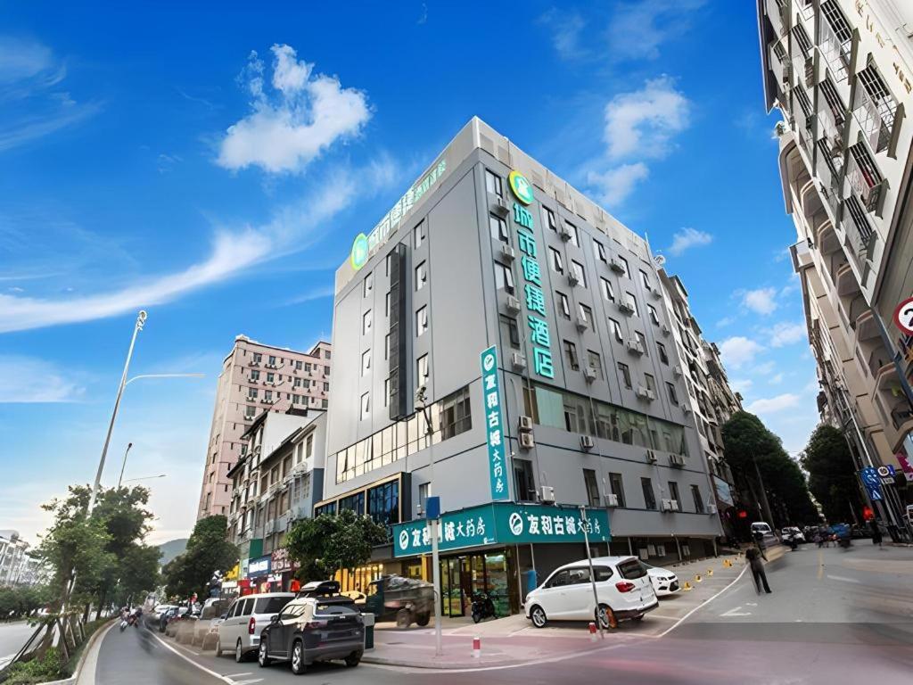 a tall building with cars parked on a city street at City Comfort Inn Nanning Yudong Jinxiang Metro Station in Nanning