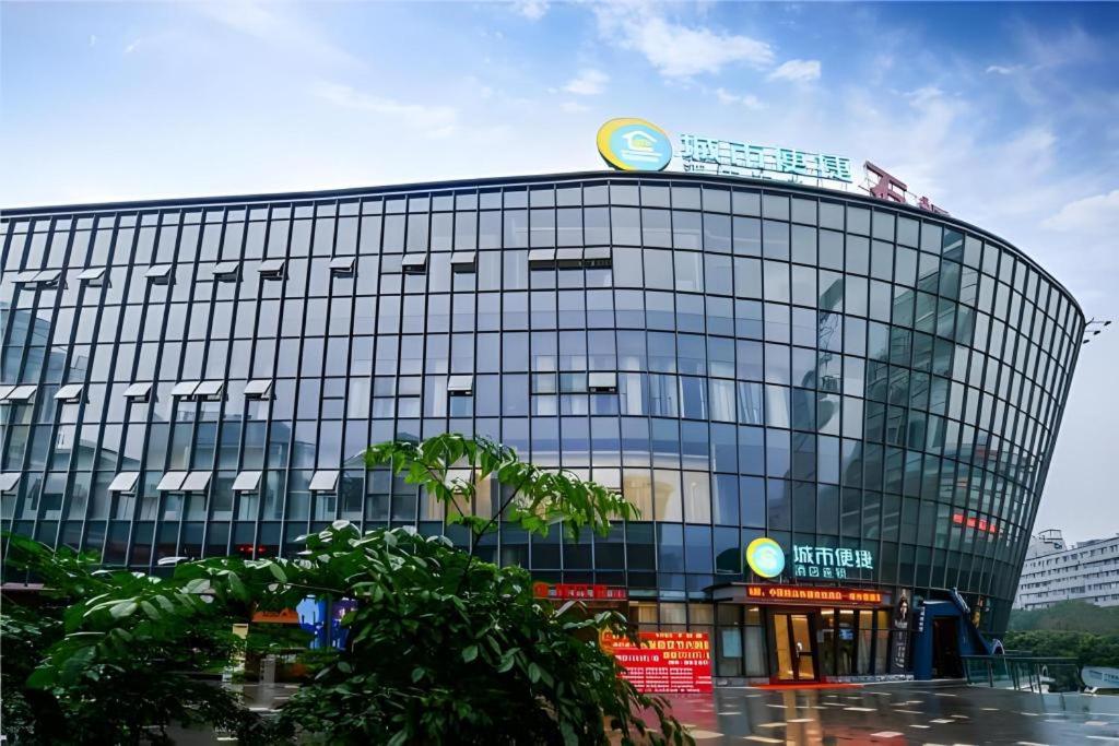 a large glass building with a sign on top of it at City Comfort Inn Chongqing Shiqiao Plaza Metro Station in Sha-p'ing-pa