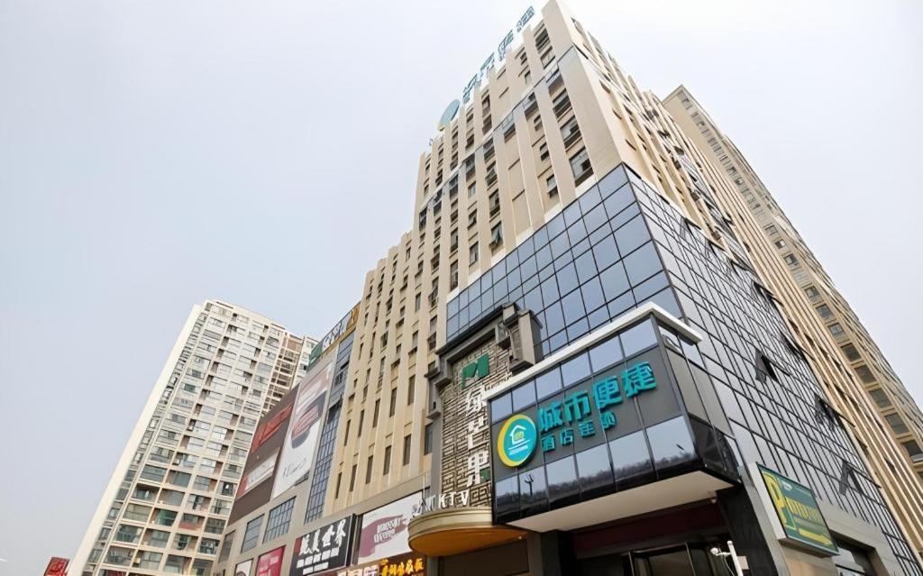 a tall building with a sign in front of it at City Comfort Inn Hefei Shuanggang Fuyang Road in Hefei