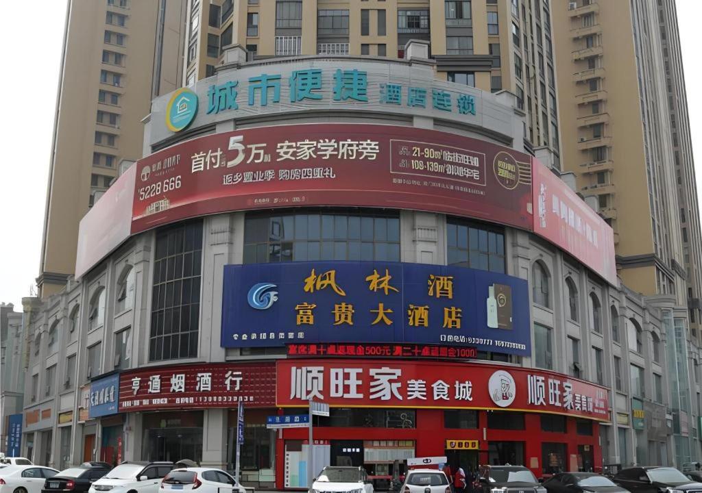 a building with signs on it in a city at City Comfort Inn Tianmen East Lake Wanda Plaza in Tianmen