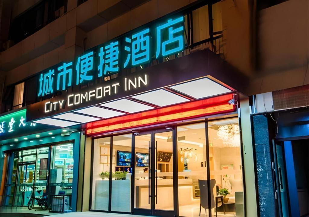un front de magasin avec des panneaux de néon sur le côté d'un bâtiment dans l'établissement City Comfort Inn Zhangjiakou Municipal Government High-speed Railway Station North Institute, à Dongyaozi