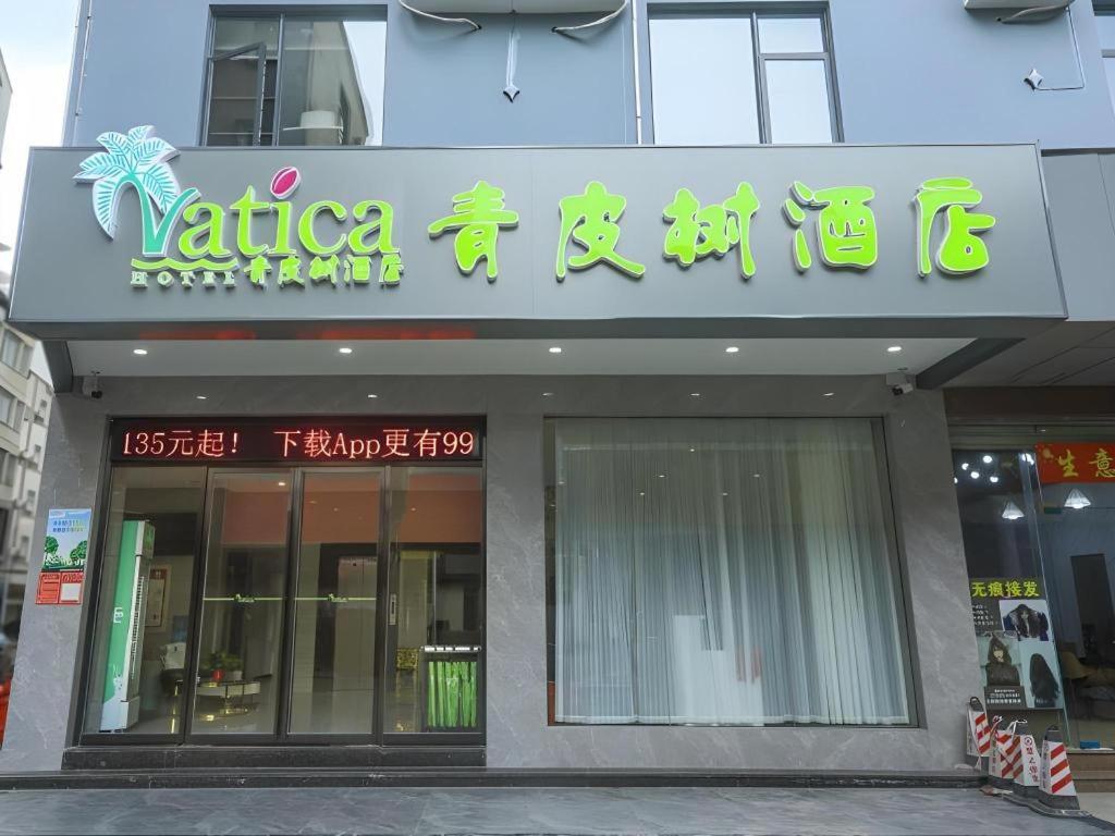 a store with a sign on the side of a building at Vatica Hotel Haikou Jinniuling Park Haizhiyuan in Haikou