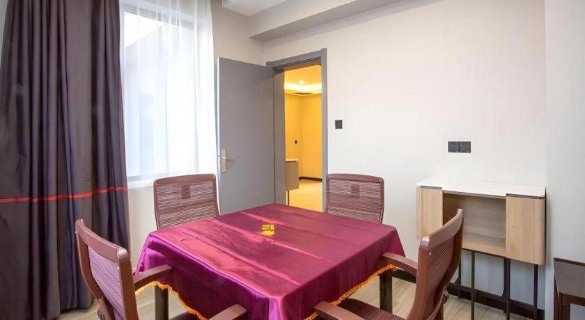 une salle à manger avec une table et des chaises rouges dans l'établissement Jun Hotel Shanxi Linfen Hongdong County Dahuaishu Xungen Jizhuyuan, à Khundun