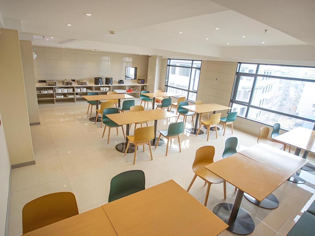 a classroom with tables and chairs in a cafeteria at City Comfort Inn Yangxin High-speed Railway Station in Huangshi