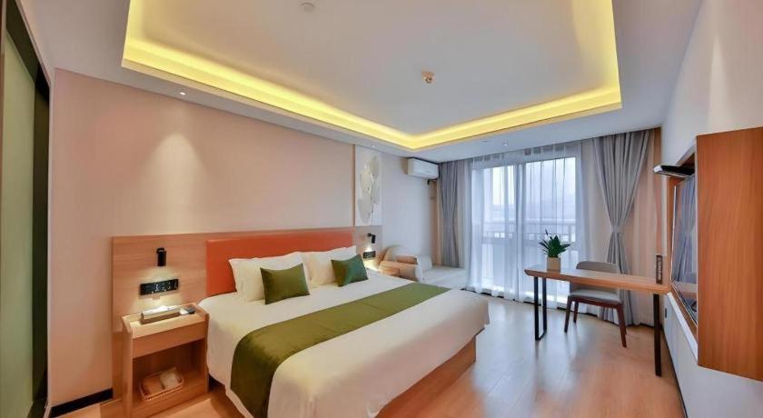 ein Hotelzimmer mit großem Bett und Schreibtisch in der Unterkunft Green Tree Inn Express Zhejiang Zhoushan Xincheng Zheda in Zhoushan