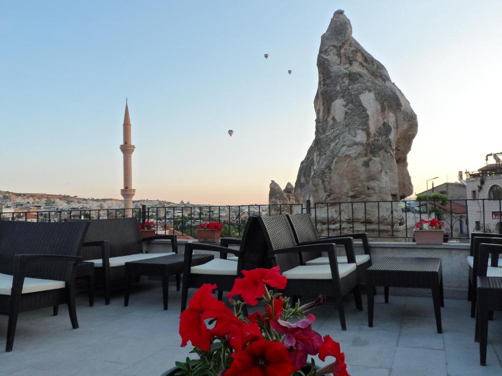 a balcony with tables and chairs and a rock at Diamond of Cappadocia in Göreme