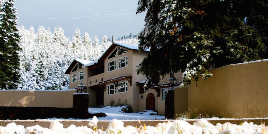 una casa con nieve en el suelo delante de ella en Shady Brook Inn Village/Resort, en Shady Brook