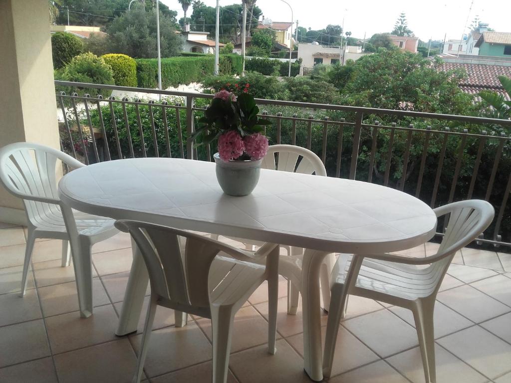 アレネッラにあるAppartamento Arenellaの白いテーブルと椅子(鉢植えの植物付)