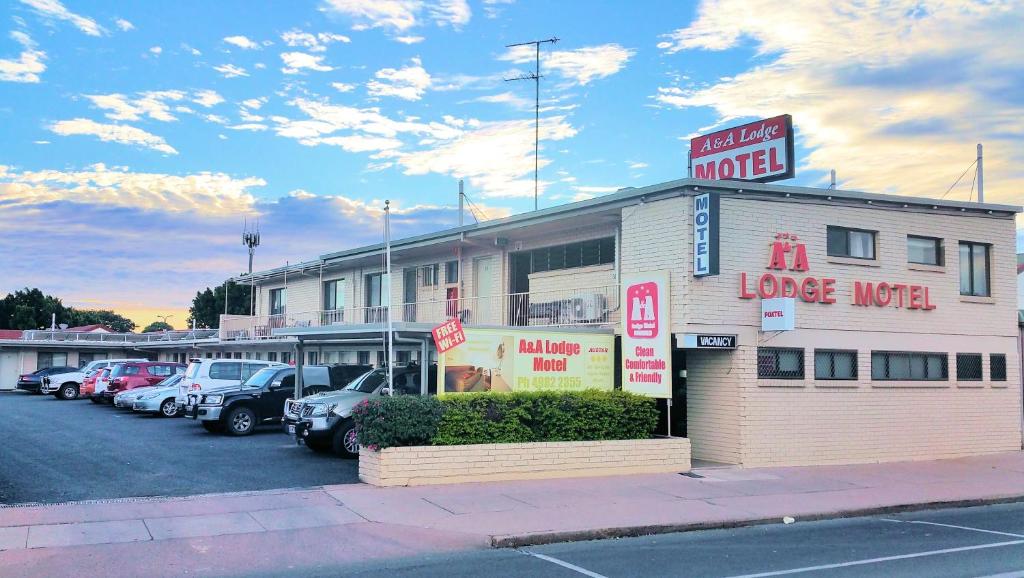 un motel grande con coches estacionados en un estacionamiento en A&A Lodge Motel, en Emerald