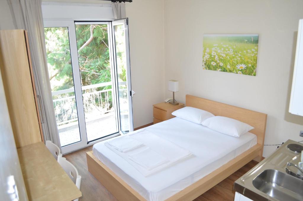 a bedroom with a bed and a window and a sink at Hotel Europa - Family and Senior Friendly in Kavála