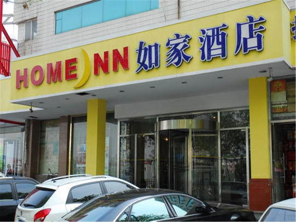 Home Inn Tianjin Weidi Avenue Culture Centre في تيانجين: منزل mm store مع سيارات متوقفة أمامه