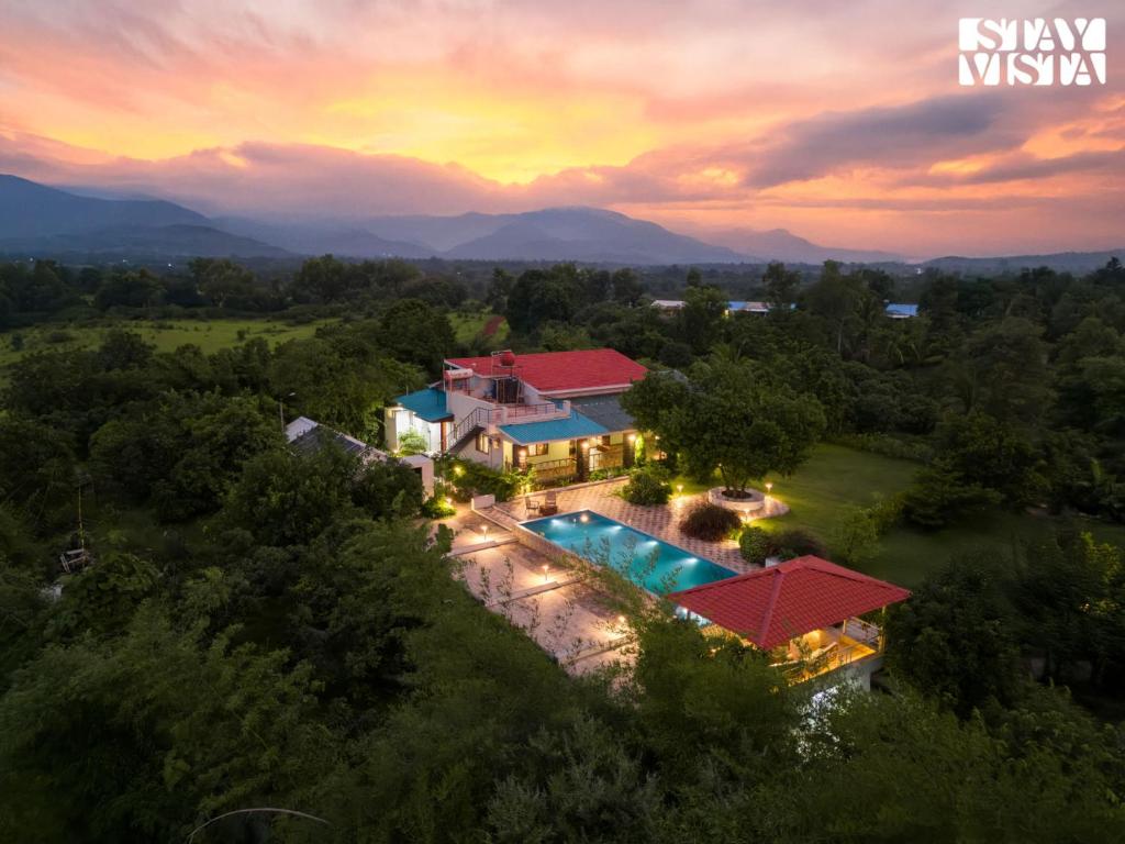an aerial view of a house with a swimming pool at StayVista at Bayleaf Villa with Pool, Lawn, Wi-Fi in Nashik